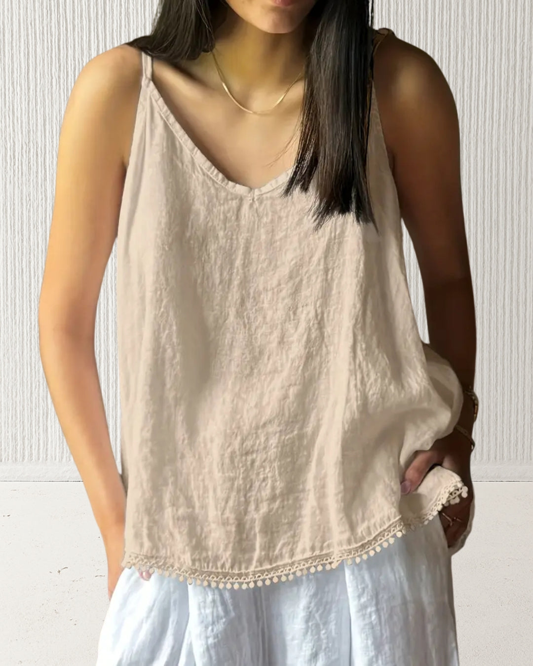 Aurora Camisole Top – Beige on model; 100% cotton V-neck with adjustable straps and subtle hem trim; relaxed summer layer.