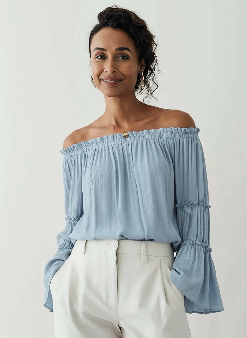 Aurora Off-the-Shoulder Ruffle Top – Blue, front view with elegant trousers; relaxed A-line fit with ruffle bell sleeves in lightweight polyester.