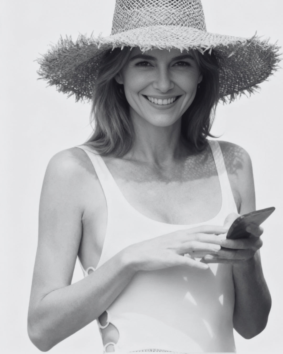 Coastal Rattan Wide Brim Straw Hat on model; natural rattan straw sun hat for beach and resort weekends.